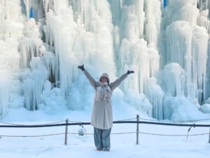 Une jeune femme posant devant un mur de fontaines gelées à Chilgapsan